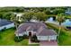 Waterfront home with a brick driveway, mature landscaping, an attached two car garage, and lake views at 4879 Brightmour Cir, Orlando, FL 32837