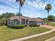 Beautiful single-story home with a 3-car garage, lush landscaping, and majestic palm trees at 4879 Brightmour Cir, Orlando, FL 32837