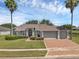 Charming single story home featuring a 3-car garage and attractive landscaping with mature palm trees at 4879 Brightmour Cir, Orlando, FL 32837