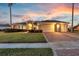 Attractive home featuring a brick-paved driveway, well-maintained lawn, and a three-car garage at 4879 Brightmour Cir, Orlando, FL 32837