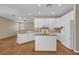 Well-lit kitchen with white cabinetry, granite countertops, stainless appliances and hardwood flooring at 4879 Brightmour Cir, Orlando, FL 32837