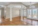 An open-concept living room with wood flooring, natural light, high ceilings, and decorative columns at 4879 Brightmour Cir, Orlando, FL 32837
