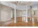 An open living room with wood floors, neutral paint, decorative columns, and backyard views at 4879 Brightmour Cir, Orlando, FL 32837