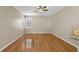 Bright living room featuring hardwood floors, a ceiling fan and white shutters on the windows at 4879 Brightmour Cir, Orlando, FL 32837