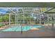 A screened-in pool area provides clear views of the backyard, pond, and neighborhood at 4879 Brightmour Cir, Orlando, FL 32837