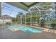 Screened-in pool area offering a relaxing outdoor retreat with lush landscaping and a view of the lake at 4879 Brightmour Cir, Orlando, FL 32837