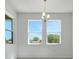 Dining room with an elegant chandelier, large windows providing natural light and a view of the greenery outside at 4998 Abigail Dr, Lake Wales, FL 33859