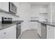 Bright kitchen with granite counters, stainless appliances, white cabinets, and gray tile flooring at 4998 Abigail Dr, Lake Wales, FL 33859