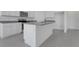 Modern kitchen with granite countertops, stainless steel appliances, white cabinets, and gray tile flooring at 4998 Abigail Dr, Lake Wales, FL 33859