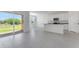 Bright living room with gray tile flooring, sliding glass doors, and an open layout to the modern kitchen at 4998 Abigail Dr, Lake Wales, FL 33859