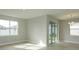 Open living space with a sliding glass door, large window, and light wood-look flooring at 5006 Abigail Dr, Lake Wales, FL 33859