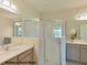 Modern bathroom featuring double vanity sinks, a framed mirror, and a glass-enclosed shower at 524 Silver Palm Dr, Haines City, FL 33844