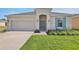 Charming single-story home with a two-car garage, well-maintained lawn and beautiful, complimentary landscaping at 524 Silver Palm Dr, Haines City, FL 33844