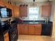 The efficient kitchen has black appliances, wood cabinets, durable black countertops and bright tile flooring at 529 Del Mar Dr, Lady Lake, FL 32159