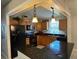 The efficient kitchen features black appliances, wood cabinets, durable black countertops and bright tile flooring at 529 Del Mar Dr, Lady Lake, FL 32159