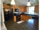 The efficient kitchen boasts black appliances, wood cabinets, and durable black countertops at 529 Del Mar Dr, Lady Lake, FL 32159