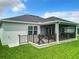 Backyard featuring a grill, patio, screened-in porch with furniture and well-manicured grass at 6633 Holovak Ter, The Villages, FL 34762