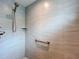 Tiled shower featuring a shower head, corner shelf, and grab bar for added safety at 6633 Holovak Ter, The Villages, FL 34762