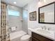 Contemporary bathroom featuring white tiling, a shower with a curtain, and a dark wood vanity at 6633 Holovak Ter, The Villages, FL 34762
