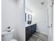 Bathroom featuring a double vanity, sleek gray cabinets, modern fixtures, and wood-look flooring at 6633 Holovak Ter, The Villages, FL 34762