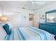Bright bedroom showcasing a striped comforter, light walls, closet, and a coordinating dresser with mirror at 6633 Holovak Ter, The Villages, FL 34762