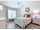 Serene bedroom featuring a large window, white furniture, and vaulted ceilings at 6633 Holovak Ter, The Villages, FL 34762