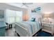 Bright bedroom featuring large window, coastal decor, and a comfortable queen-size bed at 6633 Holovak Ter, The Villages, FL 34762