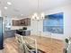 Dining room and kitchen featuring stainless steel appliances, gray cabinets, and a wood dining table at 6633 Holovak Ter, The Villages, FL 34762