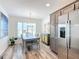 Open dining area with modern decor, a wooden table, gray cabinets, and stainless steel refrigerator at 6633 Holovak Ter, The Villages, FL 34762