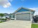 Charming home featuring a well-maintained front yard, a gray two-car garage, and a gray exterior at 6633 Holovak Ter, The Villages, FL 34762