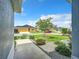 Well-manicured front yard with a circular garden, lush lawn, decorative stones, and colorful landscaping at 6633 Holovak Ter, The Villages, FL 34762