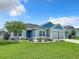 Charming single-story home with blue accents, a well-manicured lawn, and landscaped flower beds at 6633 Holovak Ter, The Villages, FL 34762