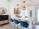 Eat-in kitchen featuring a breakfast bar with pendant lighting, stainless appliances, and modern finishes at 6633 Holovak Ter, The Villages, FL 34762