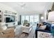 Bright living room featuring a ceiling fan, large windows, modern decor, and comfortable seating at 6633 Holovak Ter, The Villages, FL 34762