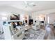 Bright living room with neutral walls, modern furnishings, and open access to the kitchen and front door at 6633 Holovak Ter, The Villages, FL 34762