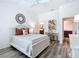 Bright main bedroom featuring a ceiling fan, decorative mirror, ensuite bath access, and a work desk at 6633 Holovak Ter, The Villages, FL 34762