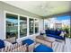 Inviting covered patio featuring comfortable seating, ceiling fan, and sliding glass doors at 6633 Holovak Ter, The Villages, FL 34762