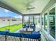 Relaxing covered patio with comfortable seating, a ceiling fan, and views of the lush backyard at 6633 Holovak Ter, The Villages, FL 34762