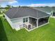 Aerial view of home showcasing screened lanai, fenced patio, and green backyard at 6633 Holovak Ter, The Villages, FL 34762