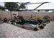 Beautiful backyard oasis with decorative rock, fish pond, foliage, and paver patio at 664 Mission Hills Trl, The Villages, FL 32162