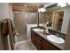 Bathroom features a double sink vanity, a large mirror, and a walk-in shower with frosted glass at 664 Mission Hills Trl, The Villages, FL 32162