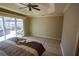 Bedroom featuring a tray ceiling, ceiling fan, wood-look floors and access to the outdoor living area at 664 Mission Hills Trl, The Villages, FL 32162