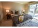 A bright bedroom with hardwood floors, a tray with books, and a sliding glass door to the patio at 664 Mission Hills Trl, The Villages, FL 32162