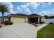 Inviting single-Gathering home with a neutral exterior, a red roof, and a two-car garage at 664 Mission Hills Trl, The Villages, FL 32162