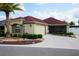 Charming home featuring a well-manicured lawn, a vibrant palm tree, and a red roof at 664 Mission Hills Trl, The Villages, FL 32162