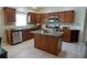Kitchen featuring an island, stainless steel appliances, dark wood cabinetry and tiled backsplash at 664 Mission Hills Trl, The Villages, FL 32162