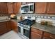 Modern stainless steel oven and microwave sit between wooden cabinetry in this well lit kitchen at 664 Mission Hills Trl, The Villages, FL 32162