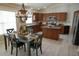 Spacious kitchen with dark wood cabinets, stainless steel appliances, and adjacent dining area at 664 Mission Hills Trl, The Villages, FL 32162