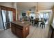 Open-concept kitchen island, stainless steel appliances, and living room with natural light at 664 Mission Hills Trl, The Villages, FL 32162