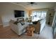 Open living room area has gray sofas and chairs, area rug, ceiling fan and sliding glass doors at 664 Mission Hills Trl, The Villages, FL 32162